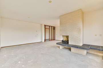 A lightly furnished living room showcases a modern minimalist aesthetic, featuring a brick fireplace and neutral-toned walls. Ideal for contemporary home designs.