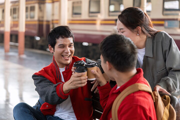 Cheers and Togetherness. Friends toast with coffee cups while waiting for their train, celebrating their journey.