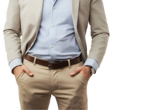 A smartly dressed man in a beige suit and blue shirt with hands in pockets.