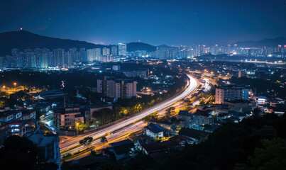 Obraz premium Nighttime cityscape with illuminated highways and buildings, showcasing urban life and traffic flow in a vibrant metropolis.