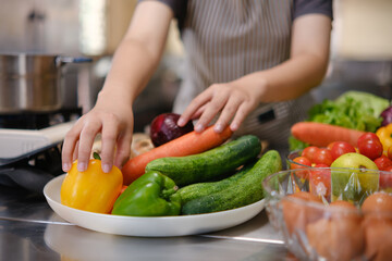 Culinary student standing confidently in training kitchen with fresh ingredients ready for cooking practice