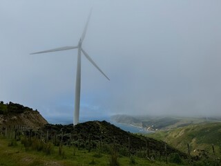 Windfarm turbine along the scenic hilltop coast of New Zealand