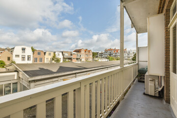 A serene balcony view showcasing an urban landscape with charming buildings and a partly cloudy sky, creating a pleasant atmosphere.