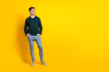 Smiling young man in casual outfit posing against vibrant yellow background, expressing joy and confidence