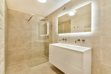 A stylish and contemporary bathroom featuring a glass shower, sleek vanity, and warm lighting, emphasizing minimalist design elements and functionality.