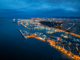 Aerial photo of Port of Barcelona at night with city lights and cruise ships
