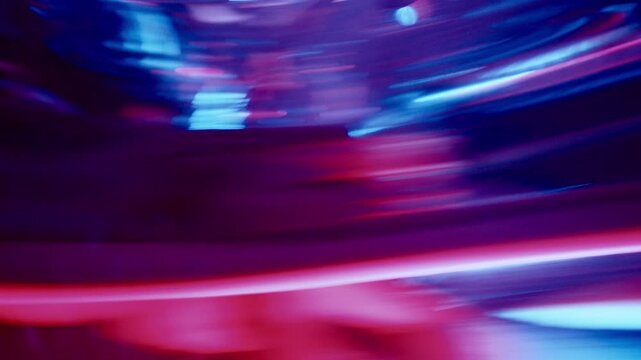 Young surprised woman looking at her warped reflection in distorting mirror during contemporary dance performance in studio with multicolored lighting