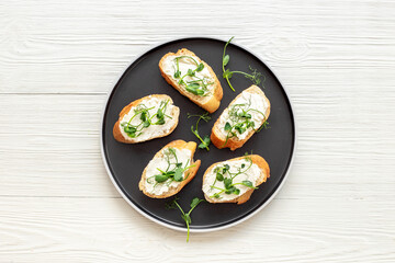 Healthy snack - sandwiches with microgreens on plate, top view