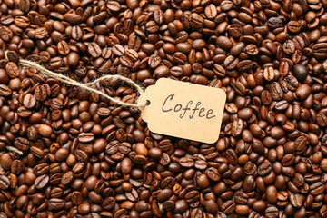 Shopping tag with word COFFEE on aromatic roasted beans