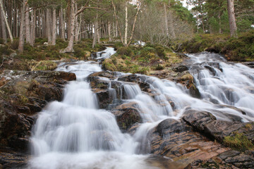 A beautiful cascade waterfall in the middle of the Cairngorms National Park in Scotland.