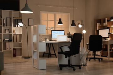 Interior of programmer's office with desks and glowing lamps