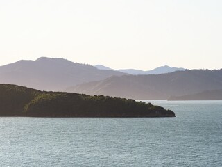 Golden hour soft light nature landscape of Queen Charlotte Sound green rolling hills forest seascape at Karaka Point Picton Marlborough New Zealand