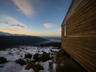 Luxmore Hut Kepler Track mountain refuge cabin in snow covered alpine winter Southern Alps landscape, Lake Te Anau Southland South Island New Zealand