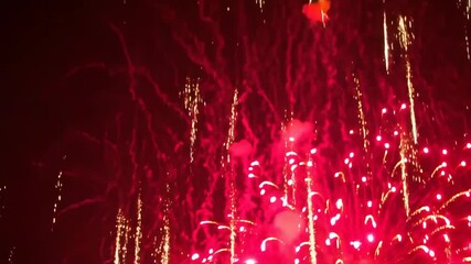 Dynamic burst of pyrotechnic sparks radiating outwards during nighttime fireworks display. Visual for holidays, festivals, or grand finale celebrations.