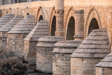 Detail of the Roman bridge of C&oacute;rdoba, Andalusia, Spain, with its arches and buttresses at sunset, a UNESCO World Heritage city