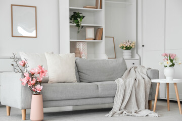 Interior of light living room decorated for Mother's Day with sofa and flowers