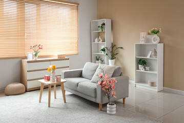 Interior of living room decorated for Mother's Day with sofa, table and shelf units
