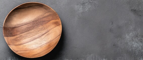 Wooden plate on a dark gray background, top view with copy space for text