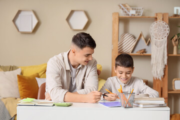Little boy with male teacher studying at home