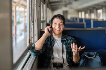 Fototapeta premium Travel and Connectivity. A young man happily chatting on the phone while embarking on a journey.