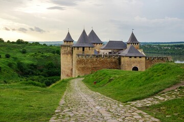 Majestic medieval Khotyn Fortress in Ukraine, with its stone walls and towers, overlooking the green landscape and river. Historical landmark.