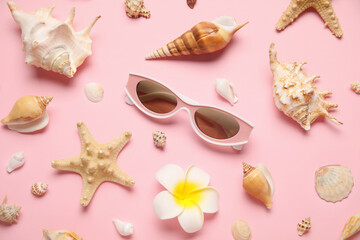 Many sea shells, sunglasses and flowers on pink background