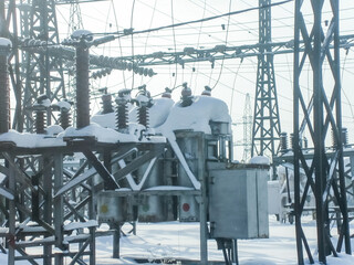 Power station equipment in winter covered by snow. Industrial electricity generation facility,...