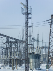 Electric power substation in winter landscape. High equipment facility with transformer, insulators and tower construction. Transmitting electrical energy illustration.
