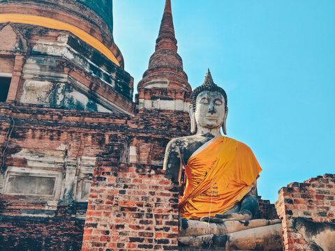 Close-up view of large Buddha statue draped in yellow robes in Ayutthaya, Thailand.  - Powered by Adobe