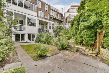 A serene garden with lush greenery and a modern home in the background. The space showcases a perfect blend of nature and architecture.