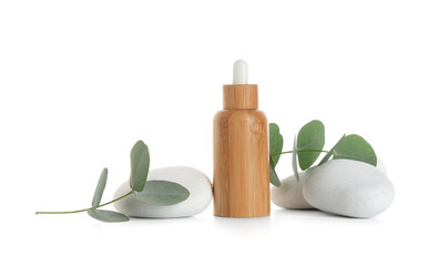Composition with bottle of essential oil, spa stones and eucalyptus branch on white background