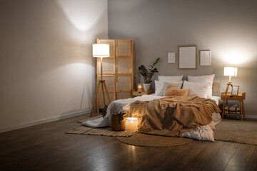 Interior of cozy bedroom with frames, plants and glowing lamps in evening