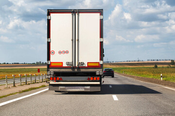A beautiful truck transports cargo along the highway in the summer. Concept of a cargo transport company. Work and vacancies as a freight forwarder driver. Copy space for text