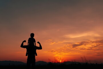 Obraz premium Silhouette of father carrying child on shoulders at sunset, showcasing strength and familial love.