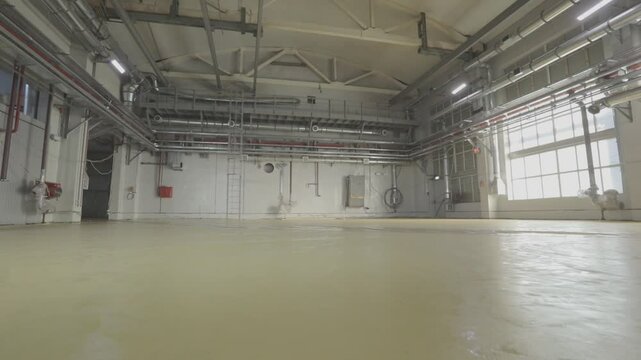 Self-leveling floors. Renovation or remodeling in an industrial workshop. Industrial or polymer flooring in a manufacturing facility.