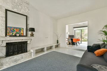 A stylish modern living room featuring a marble fireplace, contemporary art, and a cozy seating area that blends comfort with sophistication.