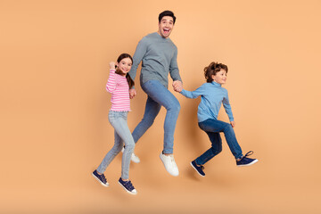 Obraz premium Cheerful Family Jumping Together Against Beige Background Celebrating Happiness and Bonding