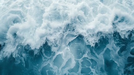 Fototapeta premium Aerial view of foamy ocean waves churning and crashing, creating a dynamic and textured seascape.