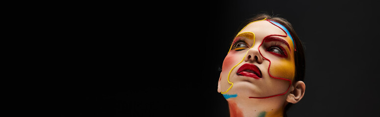 Vibrant face art adorns a young beautiful woman in an expressive moment of creativity and style