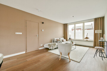 A well-lit, modern living room featuring minimalist furniture, large windows, and neutral color tones, creating a cozy yet stylish atmosphere.