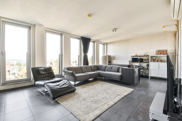 A stylish and contemporary living room featuring large windows that offer a scenic view, sleek furniture, and a cozy atmosphere perfect for relaxation.