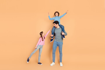 Joyful family moment with father, son, and daughter bonding and enjoying time together against a beige background