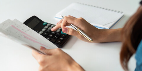Expense Calculation and Budgeting. An individual engaged in calculating their financial expenditures using a calculator.