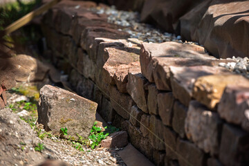 Close-up of a dry stone wall built with red Vosges sandstone, showing irregularly shaped blocks...