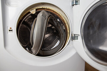 An old torn rubber seal for the sunroof with a defect, in the washing machine. Replacement of faulty spare parts, industry