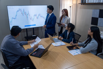 Fototapeta premium Team meeting in a modern office discussing financial trends and data analysis during the day