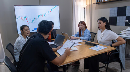 Group of professionals collaborating on a business project with charts displayed in a modern office setting