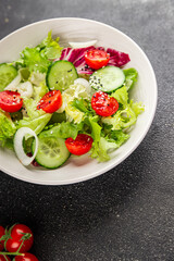 Vegetable salad tomato, cucumber, lettuce, green leaf lettuce, onion appetizer vegetable dish fresh gourmet food background rustic food top view copy space keto and paleo diet vegetarian vegan food