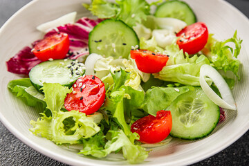 Vegetable salad tomato, cucumber, lettuce, green leaf lettuce, onion appetizer vegetable dish fresh gourmet food background rustic food top view copy space keto and paleo diet vegetarian vegan food