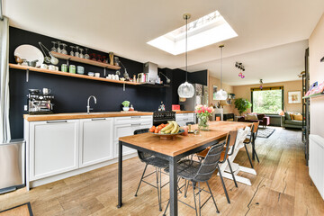 A stylish modern kitchen featuring an open layout, wooden countertops, and contemporary decor. The...